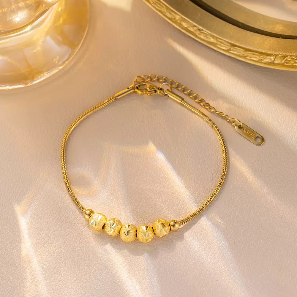 Minimalist gold snake chain bracelet with adjustable clasp. Elegant gold plated stainless steel bracelet for women. Dainty gold bracelet featuring sparkling diamond-cut bead accents. Premium adjustabl